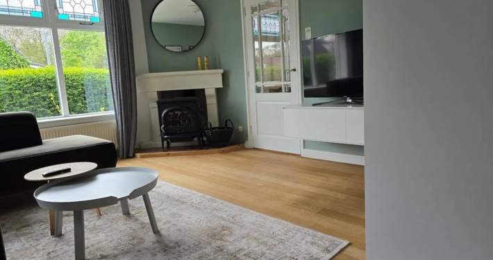 Zeetijd Petten Woonkamer met houtkachel en flatscreen TV